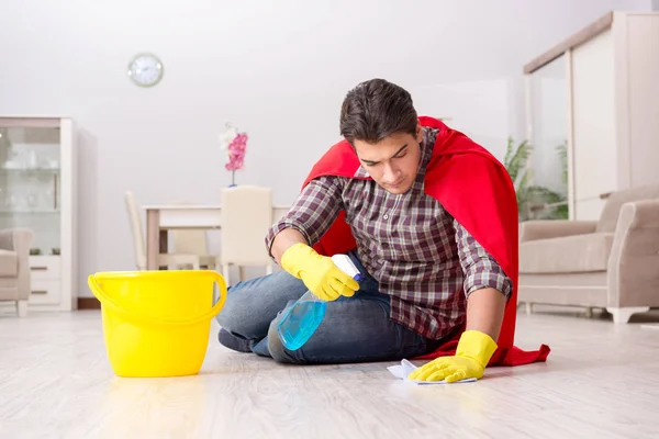 Super hero husband cleaning floor at home