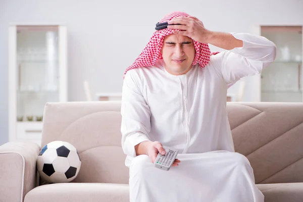 Νεαρός Άραβας που βλέπει ποδόσφαιρο καθισμένος στον καναπέ — Φωτογραφία Αρχείου