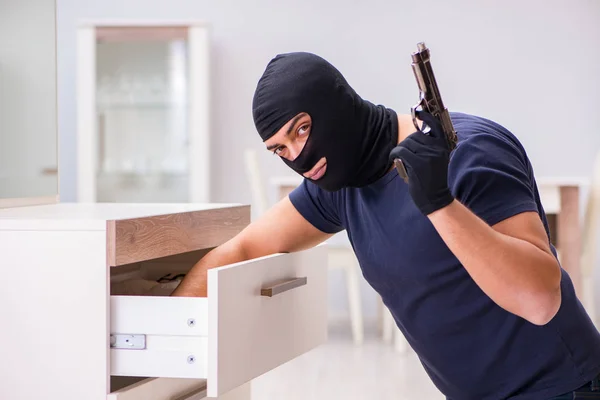 Ladrão usando balaclava roubando coisas valiosas — Fotografia de Stock