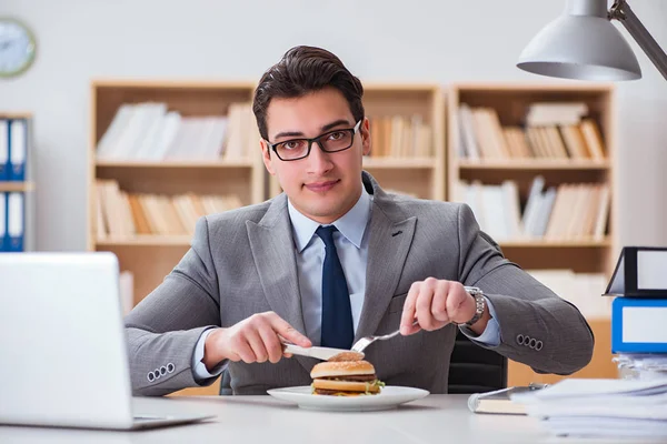 Hongerige grappige zakenman die junk food sandwich eet — Stockfoto