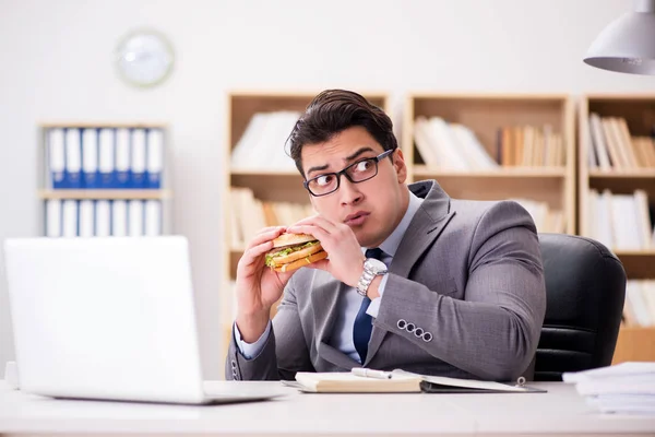 Hambriento empresario divertido comer sándwich de comida chatarra — Foto de Stock