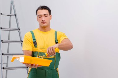 Duvarı DIY konseptiyle boyayan adam