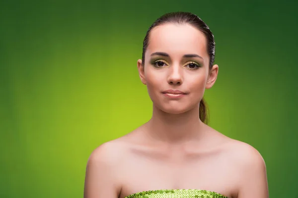 Jovem mulher no conceito de beleza no fundo verde — Fotografia de Stock