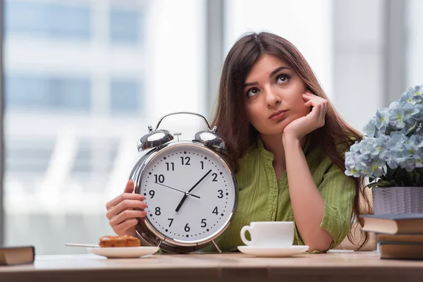 Student with gian alarm clock preparing for exams — Stock Photo, Image