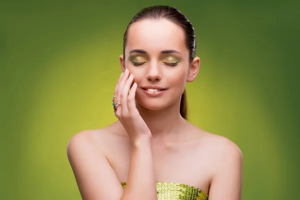 Jovem mulher no conceito de beleza no fundo verde — Fotografia de Stock