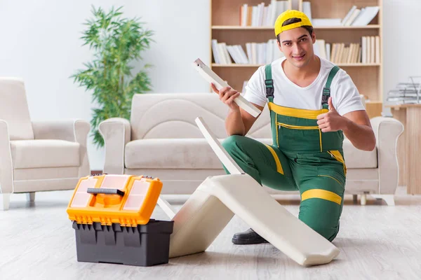 Worker repairing furniture at home