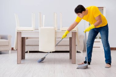 Evi temizleyen adam karısına yardım ediyor.