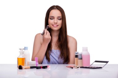 Beyazlar içinde makyaj yapan kadın.