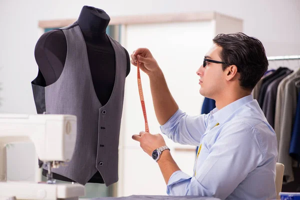 Joven sastre trabajando en ropa nueva — Foto de Stock