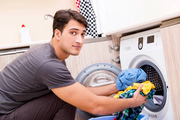 Joven marido hombre haciendo la colada en casa — Foto de Stock