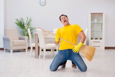 Süpürgeyle sanal gitar çalan komik adam.