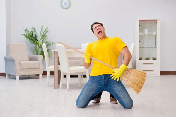 Funny man playing virtual guitar with broom — Stock Photo, Image