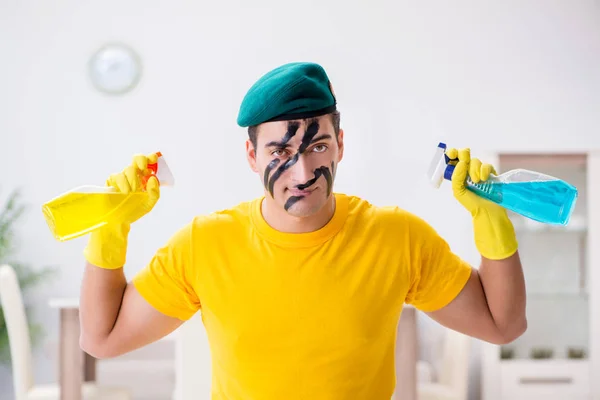 Man in military style cleaning the house — Stock Photo, Image