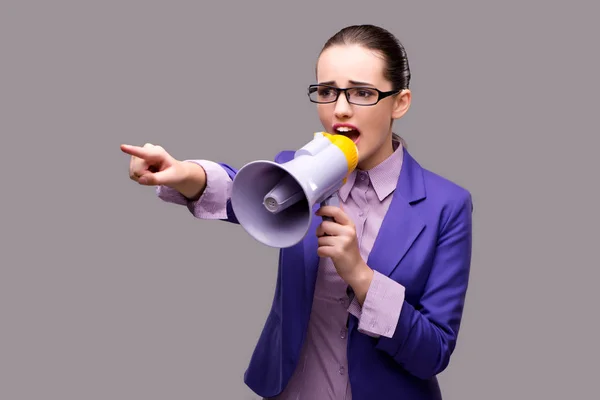 Jonge zakenvrouw met luidspreker op grijze achtergrond — Stockfoto