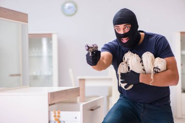 Soyguncu kar maskesi takıp değerli şeyler çalıyor.