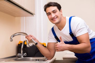 Mutfakta çalışan genç tamirci.