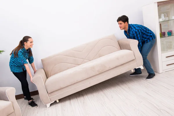 Wife and husband moving sofa couch — Stock Photo, Image