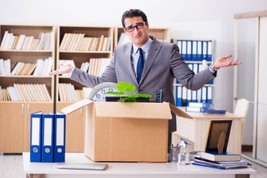 Young businessman moving offices after being made redundant clipart