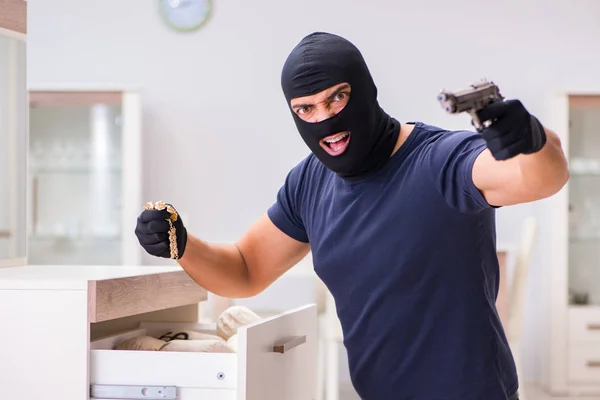 Ladrão usando balaclava roubando coisas valiosas — Fotografia de Stock