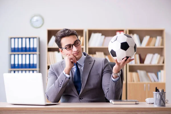 Бизнесмен с футбольным мячом в офисе — стоковое фото