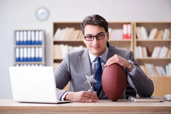 Empresario con fútbol americano en la oficina — Foto de Stock