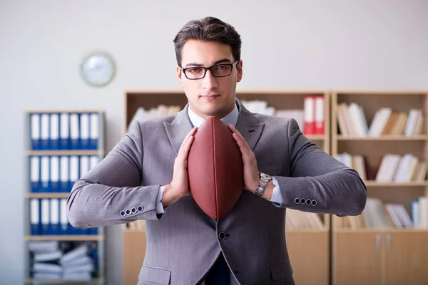 Empresario con fútbol americano en la oficina —  Fotos de Stock