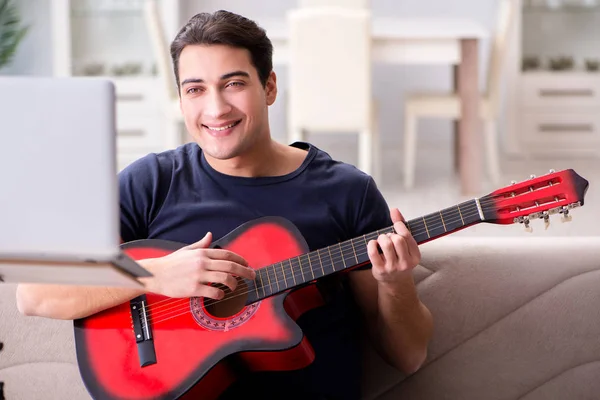 Joven practicando la guitarra en casa — Foto de Stock