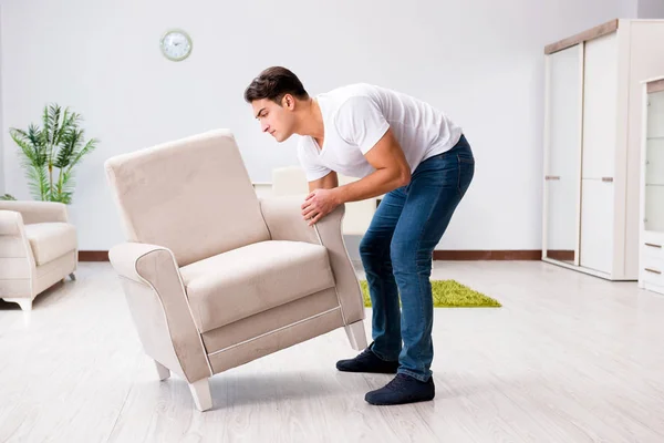 Hombre joven moviendo muebles en casa —  Fotos de Stock