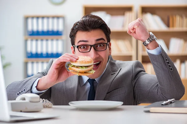 Hungrig rolig affärsman äter skräpmat smörgås — Stockfoto