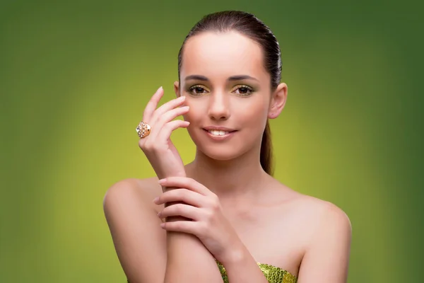 Mujer joven en concepto de belleza sobre fondo verde — Foto de Stock