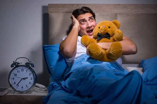 Young man scared in bed — Stock Photo, Image
