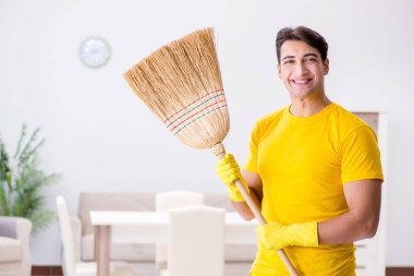 Koca adam evi temizliyor, karısına yardım ediyor.