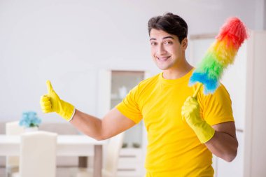 Koca adam evi temizliyor, karısına yardım ediyor.