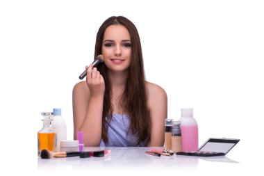 Beyazlar içinde makyaj yapan kadın.