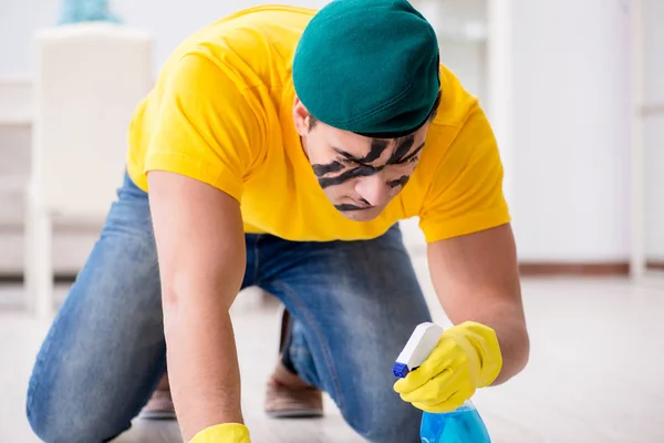 Άντρας σε στρατιωτικό στυλ να καθαρίζει το σπίτι. — Φωτογραφία Αρχείου