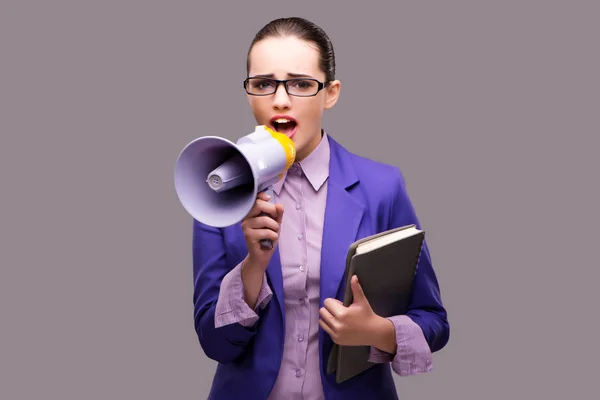 Young businesswoman with loudspeaker on gray background — Stock Photo, Image