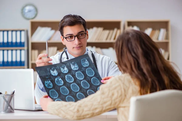 Junger Arzt schaut sich Computertomographie-Röntgenbild an — Stockfoto