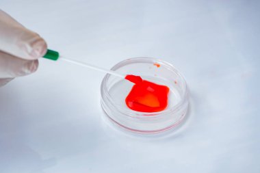 Laboratuvar hastanesinde kan testi üzerinde çalışan genç bir doktor.