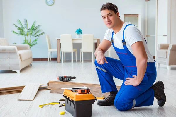 Reparador que estabelece piso laminado em casa — Fotografia de Stock