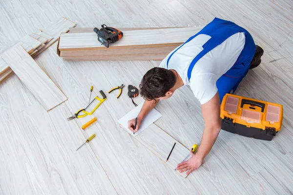 Reparador que estabelece piso laminado em casa — Fotografia de Stock