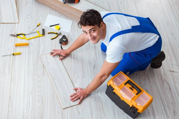 Repairman berbaring laminasi lantai di rumah — Stok Foto