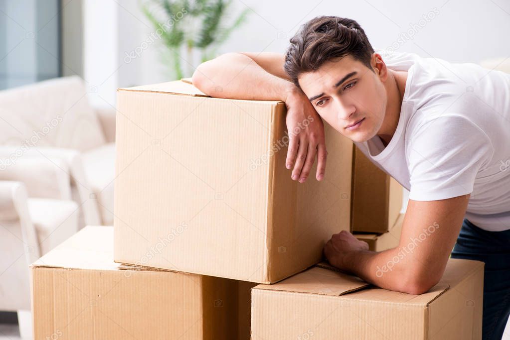 Young man moving boxes at home