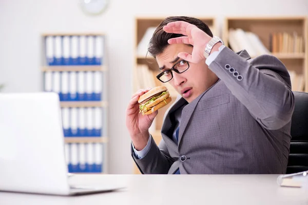 Hungry funny businessman eating junk food sandwich — Stock Photo, Image