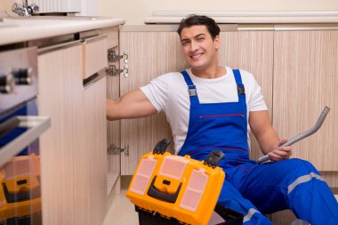 Mutfakta çalışan genç tamirci.