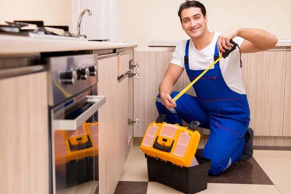 Joven reparador trabajando en la cocina — Foto de Stock