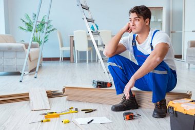 Tamirci evde döşeme kaplaması döşemiş.