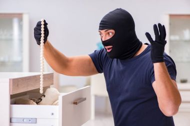 Soyguncu kar maskesi takıp değerli şeyler çalıyor.