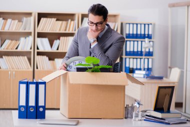 Ofisi kutu ve eşyalarıyla taşıyan bir adam.