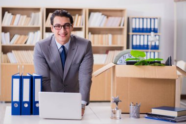 Ofisi kutu ve eşyalarıyla taşıyan bir adam.