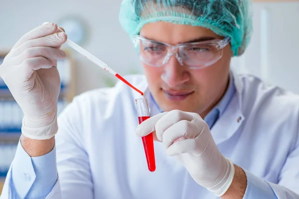 Jonge arts werkt aan bloedonderzoek in het lab ziekenhuis — Stockfoto